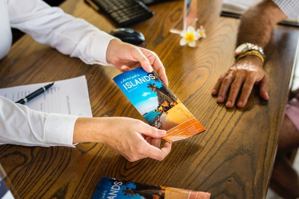 people handling a brochure