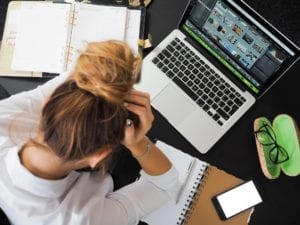 frustrated woman at desk with clutter